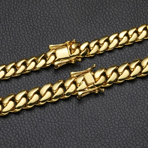 Polished gold Cuban link bracelet with butterfly box clasp on dark leather background