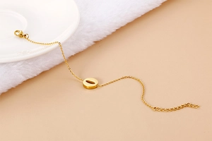 Detail of gold letter O bracelet featuring sparkling rhinestone inlay and lobster clasp