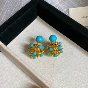 Detailed macro view of vintage turquoise resin bead flower stud earrings in jewelry box