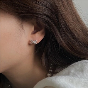 Elegant 925 sterling silver bow knot stud earrings worn by a model for a minimalist look