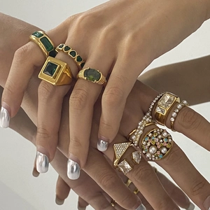 Minimalist gold plated rings set with green zircon, pearls and enamel worn on fingers