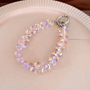 Macro shot of pink faceted crystal beaded phone strap with silver spring buckle closure