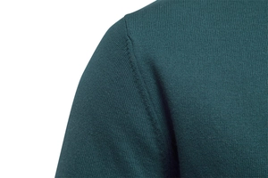 Detailed macro view of the fine shoulder seam on a dark green knit cardigan for men