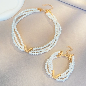 Ensemble élégant collier multi-rangs en perles blanches et bracelet avec motif en V doré