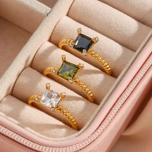Three 18K gold plated square zircon rings with black, green, and white stones in a box