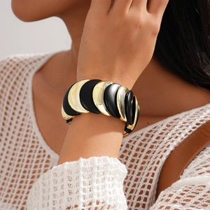 Dettaglio del bracciale elastico in acrilico con segmenti a specchio oro e nero opaco
