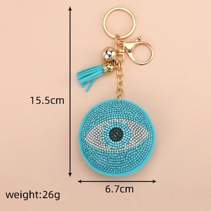 Macro view of evil eye keychain showing size 15.5cm with blue rhinestones and tassel