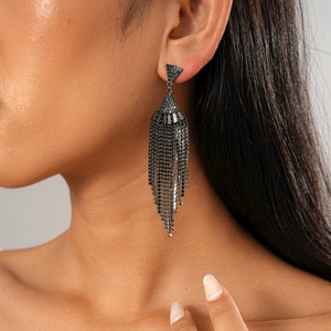 Close-up of black zircon fan-shaped tassel earring worn on ear showing drape and detail