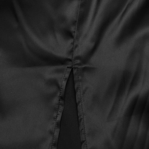 Detail view of smooth black satin fabric with precision stitching and high slit design