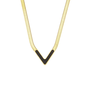 Macro detail of V-shaped black shell pendant on flat golden snake chain necklace