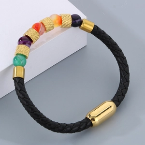 Dettaglio del bracciale in pelle intrecciata con chiusura magnetica e perle colorate
