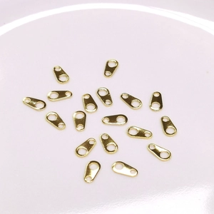 14k gold-filled oval connector plates for DIY jewelry making scattered on white