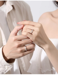 Close-up of couple holding hands wearing matching 925 silver rings with twisted design
