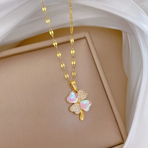 Macro detail of aurora clover necklace with micro-pave diamonds on beige jewelry box