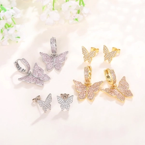 Macro view of butterfly earrings with pavé crystals in gold and silver finishes