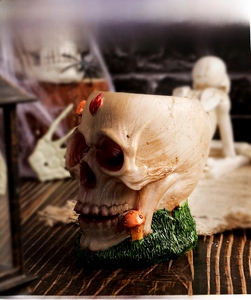 Detailed resin skull with orange mushrooms and green grass for Halloween decor
