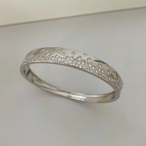 Gros plan du bracelet jonc argenté serti de zircons colorés et finition polie