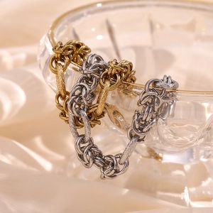Detail of gold and silver chunky knotted link bracelets on a glass bowl with silk background