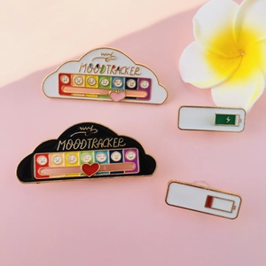 Detail of sliding heart tracker enamel pin showing social battery and mood cloud design