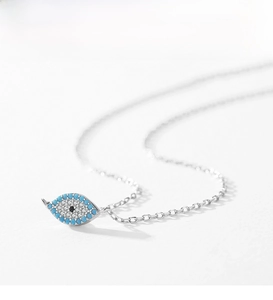 Macro detail of S925 sterling silver evil eye necklace with turquoise beads and pavé crystals