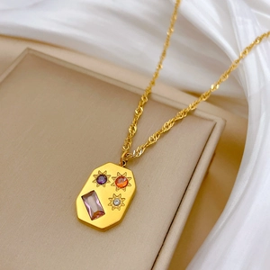 Detailed macro view of gold titanium steel necklace with starburst gems and purple stone