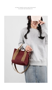 Model wearing a burgundy thick canvas tote bag with khaki straps and a shoulder strap