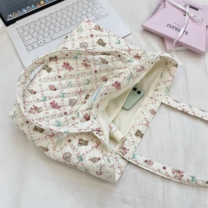 Macro view of floral and cartoon animal patterns on large quilted cotton tote bag