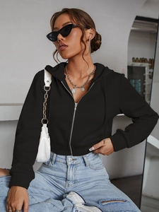 Women's black cropped zip-up hoodie paired with light blue distressed denim jeans