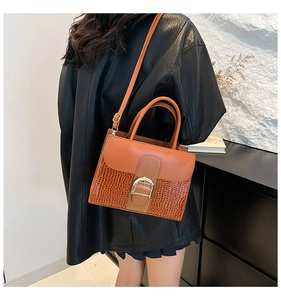 Détail du sac à main en cuir à motif pierre avec boucle métallique dorée en fer à cheval