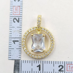Detailed view of gold round pendant with square zircon and ruler showing 2.5cm size
