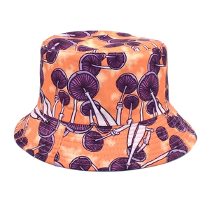 Detailed view of vibrant orange bucket hat featuring dense purple mushroom print patterns