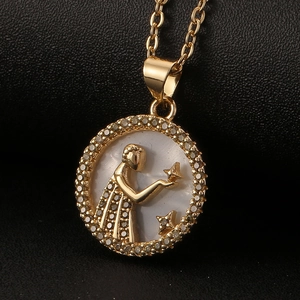Detail of gold zodiac pendant with white mother of pearl and crystal pavé setting