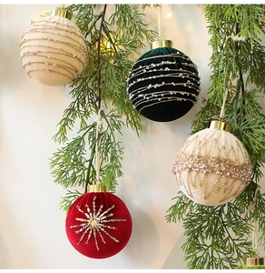 Close-up of velvet Christmas ornaments with gold glitter and beads on pine branches