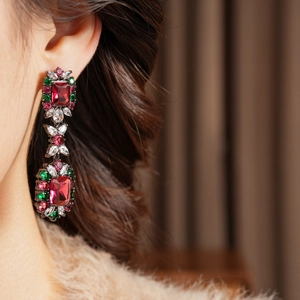 Detail of vintage drop earrings with red ruby zircon and green stones on model