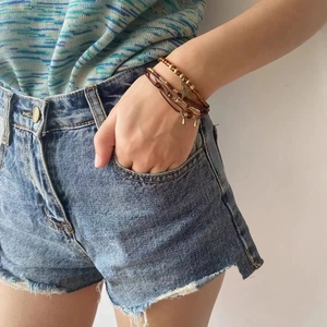 Bracelet bohème multicouche avec perles marron et pendentifs étoiles sur poignet féminin