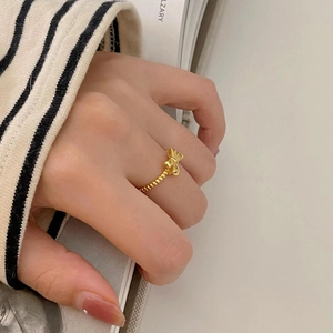 Detail of a 925 sterling silver golden bow ring with beaded band on a hand