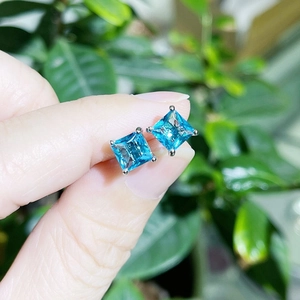 Detailed view of light blue square princess cut zircon stud earrings in silver claws