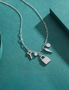 Macro detail of S925 silver key and lock necklace with pavé crystal accents