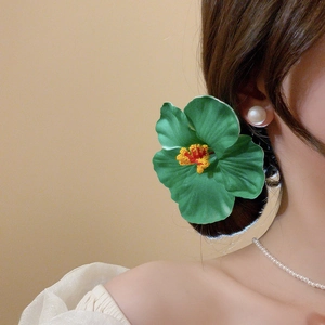 Detailed view of realistic green hibiscus flower hair clip styled on elegant dark hair