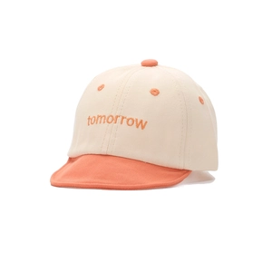 Détail de la casquette bébé en coton avec broderie orange et visière courte souple