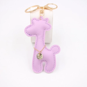 Close-up of purple PU leather giraffe keychain with gold metal hardware and small charm