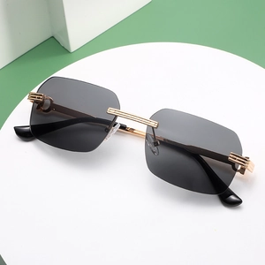 Detalle de la bisagra dorada en forma de C en las gafas de sol con lentes degradados