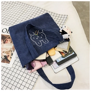 Deep blue corduroy tote bag with embroidered rabbit showing large storage capacity