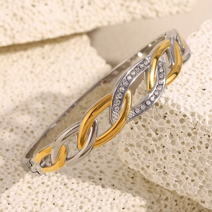Close-up of gold and silver plated stainless steel bangle with zircon eye motif and clasp