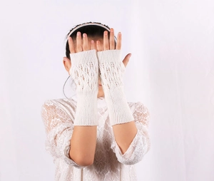 Detail of cream knitted fingerless gloves showing intricate leaf hollow-out pattern