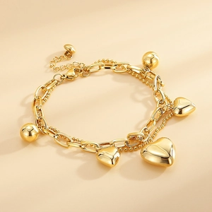 Macro shot of 18K gold plated double-layer titanium bracelet with heart and bead charms