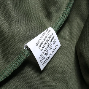 Macro shot of 100% polyester fabric texture and wash care label on green sports shorts