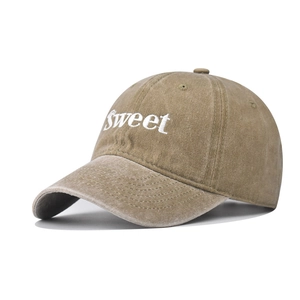 Detail of Sweet embroidery on khaki washed cotton baseball cap with vintage texture