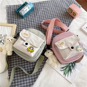 Vue détaillée des sacs bandoulière en toile vert menthe et rose avec bandoulière et ours