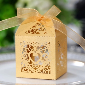 Close-up of laser-cut heart candy box in gold pearlescent paper with ribbon